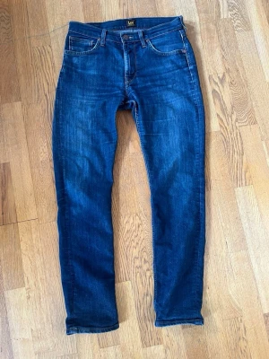 Mörkblå Jens från lee - Snygga mörkblå jeans från Lee i Klassisk femficksdesign med Lee-logga på bakfickan. Jeansen har normal midja och raka ben. Tillverkade i mjukt denimtyg som ger en skön känsla och bra passform.