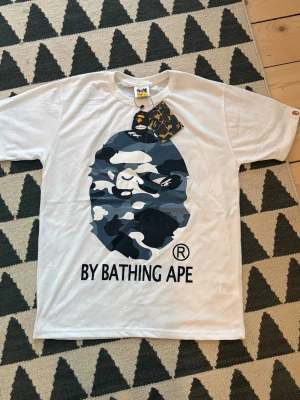 Vit BAPE t-shirt - Säljjer denna BAPE t-shirt till bra pris. Aldrig använd och säljer den för den är för stor.