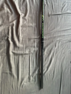 Oxdog Hyperlight innebandyklubba - Säljer en svart innebandyklubba från Oxdog, modell Hyperlight. Klubban har detaljer i neongrönt och orange, samt en stilren design med Oxdog-logga längs skaftet. Använd en eller två gånger så den är i mycket bra skick.