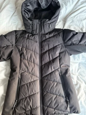 Svart dunjacka med huva - Snygg skidjacka, luvan går över hjälmen och det finns ficka för skidkort. Skriv för frågor 🥰