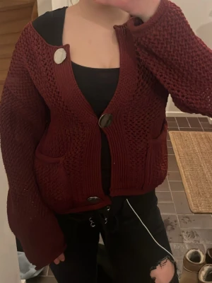 Vinröd stickad kofta från ZARA - Säljer en vinröd stickad kofta från zara som har stora guld knappar där fram, den är i storlek S och jag är 160cm, knapparna är fortfarande guliga men börjar bli silvriga