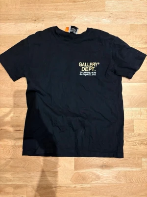 Gallery Dept T-Shirt - Tjena! Säljer en fin Gallery Dept T-Shirt med simpel text på baksidan och en extremt fin design på ryggen. Tröjan är mestadels svart med lite färger. Den är i storlek S perfekt skick, skriv för intresse! 