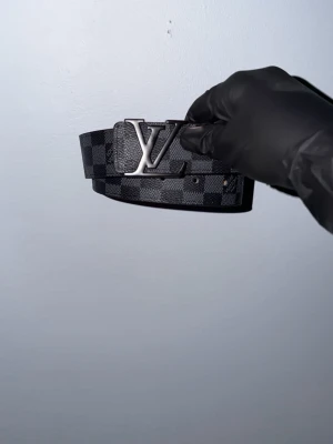 Svart bälte med rutigt mönster  - Snyggt svart bälte med rutigt mönster storlek 105cm. Skriv angående frågor eller pris.