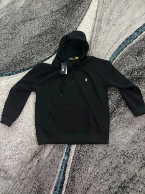 Svart hoodie från Polo Ralph Lauren - Helt ny ralph lauren hoodie som är svart.                         Den är egentligen i storlek L men det är feltryck och står XXL 