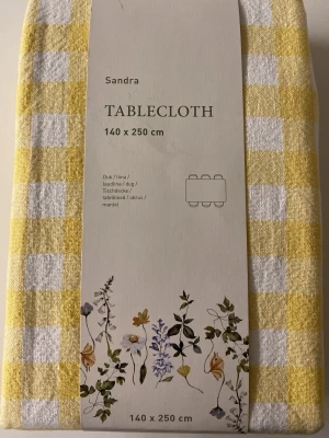 Gul och vit rutig duk 140x250 cm - Säljer en gul och vit rutmönstrad duk från Sandra i storlek 140x250 cm. Duken är tillverkad i bomull och polyester och har ett klassiskt rutigt mönster som passar perfekt till köksbordet eller matsalen.
