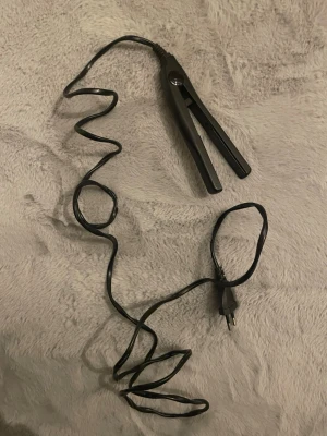 Svart plattång för styling - Jag säljer min mini plattång som är svart med sladd, perfekt för att styla håret. Plattången är enkel och smidig att ta med sig i handväskan!❤️Det är enkelt för både kort och långt hår. Passar dig som vill fixa snygga frisyrer!❤️Plattången är jätte bra och ditt hår blir snabbt klart, platttången blir snabbt varm!