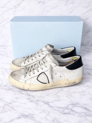 Vita Philippe model sneakers  - Vita Philippe model sneakers.                                                                         Storlek: 41.                                                                                                   Väldigt använt skick!                                                                           Priser går att diskutera                                                                               Skorna saknar innersulor och skolådan ingår ej!