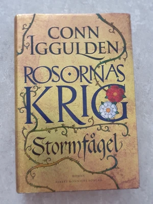 Bok - En episk historisk roman av Conn Iggulden med hård pärm i guldfärgad design och dekorativa detaljer. Boken handlar om maktkamp och intriger i England på 1400-talet, där två rivaliserande släkter slåss om tronen. Perfekt för dig som gillar historia och dramatik.