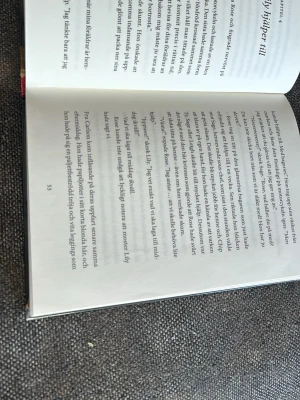 Bliss: Det magiska bageriet - En färgstark och fantasifull bok av Kathryn Littlewood med hård pärm. Omslaget visar ett magiskt bageri med bakverk i skyltfönstret och en mystisk blå virvel vid dörren. Perfekt för dig som gillar äventyr och magi i vardagen.