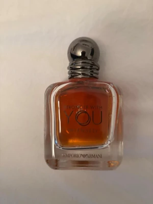 Emporio Armani Stronger With You intensly  - Emporio Armani Stronger With You Intensely parfym i en elegant, fyrkantig glasflaska med rundad silverfärgad kork. Doften har en djup bärnstensfärg och flaskan har märkets logga tryckt framtill.