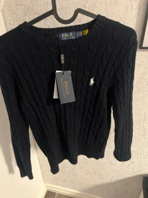  tröja Polo Ralph Lauren - Kabelstickad svart tröja från Polo Ralph Lauren storlek M men passar S väldigt liten i storleken testad 1 gång skriv vid minsta fundering.👍🏻