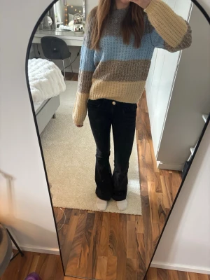 Randig stickad tröja  - Mysig stickad tröja med breda ränder i ljusblått, brun och ljusgul. Den är från Pieces och i storlek XS. Den är knappt använd och ser ut som ny.