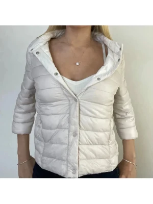 Ljusbeige trekvartsärmad jacka  - Snygg ljusbeige pufferjacka med tryckknappar framtill. Jackan har quiltad design och trekvartsärmar för en modern look. Perfekt för kalla vinterdagar och enkel att matcha med olika outfits.