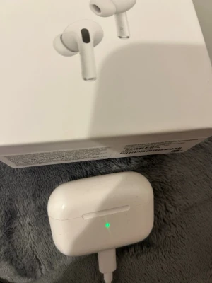 Apple AirPods Pro trådlösa hörlurar - Säljer ett par Apple AirPods Pro i vitt. De är in-ear hörlurar med stilren design och silikonproppar för bra passform. Kommer i originalförpackning med minimalistisk look. Perfekta för dig som vill ha grymt ljud och smidig anslutning till iPhone.