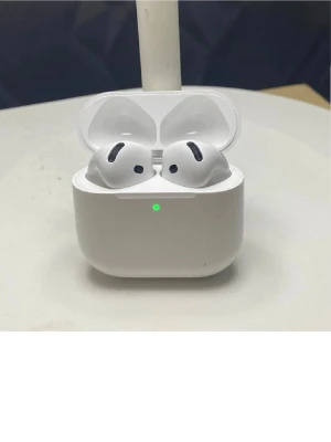 Apple AirPods 4 - Säljer ett par vita Apple AirPods Pro med laddningsetui. Hörlurarna är kompakta, har in-ear design och levereras i ett smidigt, matt vitt fodral med LED-indikator. Perfekta för musik, samtal och träning tack vare sin trådlösa frihet och stilrena look.