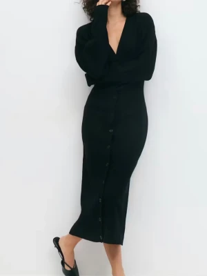 Svart långklänning från Gina Tricot - Stilren svart långklänning från Gina Tricot med v-ringning och knappar längs hela framsidan. Klänningen har lång ärm och är tillverkad i mjukt stickat material som ger en bekväm och snygg passform. Använd men i bra skick. Pris 250 kr. 