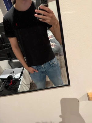 Svart t-shirt från Ralph Lauren - Säljer en (äkta!) Ralph Lauren T-shirt. Köpte den för 900kr som ny pris.                                               Den har ganska snabbt börjat bli lite för liten och det är därför jag säljer den.                                                                              Den har inga defekter inte använd mycket. Det ända är att texten innanför tröjan på sista bilden har suddats ut lite.