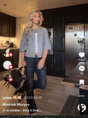 Grå cardigan jacka med knytärm - Snygg grå cardigan jacka med vida trekvartsärmar och knyt vid ärmslut. Jackan har en enkel knapp framtill och två fickor. Perfekt för dig som gillar en avslappnad men trendig stil.