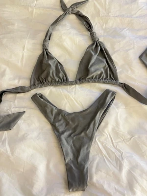 Grå bikini  - Snygg gråskimrig bikini från Bikbok, endast använd 1 gång så i bra skick. Båda delarna är i xs. Köpt för 600:-