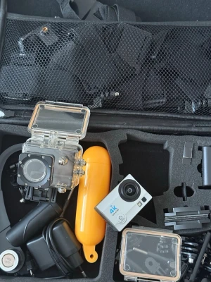 4K Ultra HD actionkamera med tillbehör - Säljer en kompakt 4K Ultra HD actionkamera i silver och svart med vidvinkellins. Kameran kommer med flera tillbehör, inklusive vattentätt hus, flythandtag i gult och olika fästen. Perfekt för äventyr och sport. Allt ligger i en praktisk skyddsväska.