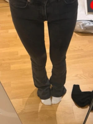 Svarta bootcut jeans med hög midja - Säljer ett par svarta bootcut jeans med hög midja och klassiska fem fickor. Jeansen har en snygg passform som sitter tight över låren och släpper ut vid vaden. Perfekta till sneakers eller boots.