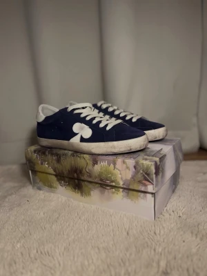 The gallerist - Säljer ett par marinblå sneakers från the gallerist med vit sula, vita snören och vit detalj på sidan. Skorna har en klassisk låg profil och är tillverkade i Portugal. Storlek 45, helt oanvända!