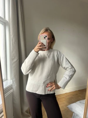 Vit stickad tröja med rund hals💖💖 - Säljer en enkel och stilren vit stickad tröja med rund hals och långa ärmar. Tröjan har ribbade muddar vid ärmslut och nederkant, vilket ger en snygg och avslappnad look. Perfekt att matcha med jeans eller byxor.