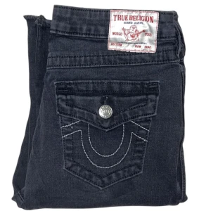 True Religion jeans - Mid-waist Bootcut True Religion jeans. W28. Klippta längst ner. [Ytterbenslängd 104cm] [Innerbenslängd 85cm] [Midja 40cm] [Benöppning 25cm]