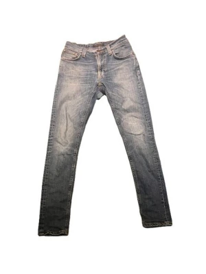 Nudie jeans  - En extremt snygg blå fade Nudie Jeans ! Storlek W29 L32 och är i väldigt bra skick! jeansen har snygga lagningar samt passar till allt och sitter extremt bra! Vi finns har for att svara på alla dina fragor! Dessutom så är priset ej hugget i sten vid snabb affär!