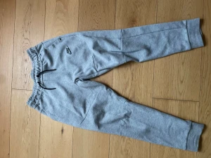 Gråa mjukisbyxor från Nike - Hej jag säljer ett par Nike tech byxor i storlek 137-147 bra skick och inga fläckar eller hål