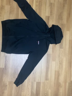 Svart hoodie från mckenzie - Svart kofta från mckenzie med mckenzie märken på armarna och märket mckenzie vid bröstet denna koftan är suveränt skick och är väldig fin att ha på sig och för att se stylig ut.