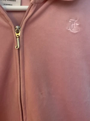Rosa juicy conture zip hoddie - Säljer en rosa juicy conture zip hoodie. Fint skick, inte mycket använd och inga synliga tecken på användning. Storleken är 14/15 år, men skulle säga att den är som en xs/s. 