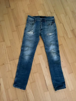 Replay jeans  - Säljer ett par replay jeans med slitningar. Är tillverkade i denim med tvättad look. Perfekta för en avslappnad och trendig stil. W31 L32