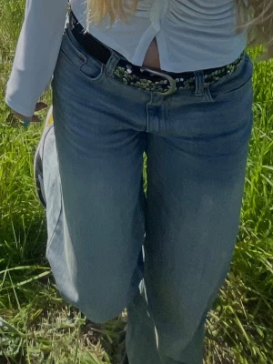 Svart läderbälte med nitar och kristaller - Snyggt svart bälte med coola detaljer. Perfekt accessoar för att ge din outfit en unik touch. Bältet har ett klassiskt spänne och passar till både jeans och kjol. Helt i läder 