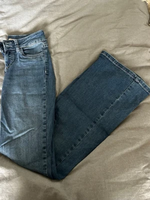 Blå bootcut jeans - Snygga jeans från Nelly med fin design på fickorna och sömmarna. Säljer då dem tyvärr inte kommer till användning längre!💕