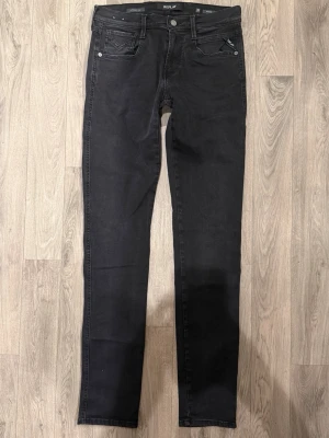 Replay Anbass Hyperflex Jeans Mörkgrå/Svarta W30/L34 - Slim Fit - Replay Anbass Hyperflex mörkgrå/svarta jeans i stretchig Hyperflex denim med slim fit passform som sitter snyggt och bekvämt och funkar till allt, storlek W30/L34, midja 39 cm, ytterbenslängd 110,5 cm, benöppning 15 cm, modellen är 185cm & väger 65kg, i fint skick.