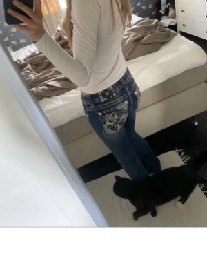 Blåa Miss Me jeans med broderade fickor - Säljer ett par blåa jeans från Miss Me med snygga fickor med detaljer och mönster. Jeansen har en klassisk femficksdesign och är i en slim fit-modell. Perfekta för dig som vill ha något unikt och trendigt i garderoben. Bootcut och I bra skick bara lite slitna nere i hälen!🌺