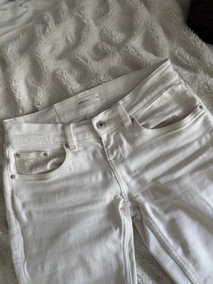 Vita jeans med detaljer från Gina  - Säljer ett par vita jeans från gina med snygga silverdetaljer och broderier på bakfickorna. Klassisk femficksmodell med raka ben och bälteshällor. Jeansen är i ett mjukt bomullsmaterial och har en fräsch, clean look.