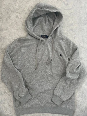 Grå Ralph Lauren hoodie - Säljer en riktigt schysst grå Ralph Lauren hoodie i storlek L 💯Passar till det mesta! 💫Pris kan diskuteras vid snabb affär