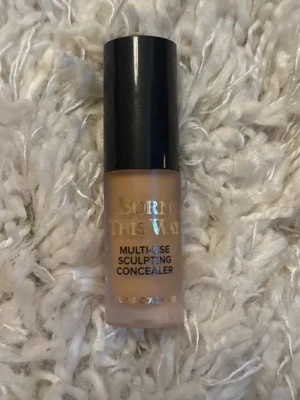 Too Faced Born This Way Concealer - Multi-use sculpting concealer från Too Faced i nyansen beige. Kommer i en cylinderformad plastförpackning med svart lock. Kan användas för att täcka, konturera, highlighta och retuschera. Perfekt för att skapa en jämn och fräsch bas.