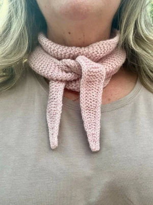 Ljusrosa Sophie Scarf - Supersöt ljusrosa stickad sjal i mjukt garn. Sjalen är smal och perfekt att knyta runt halsen för en trendig look. Passar till både jacka och tröja och ger en mysig känsla. Materialet känns mjukt och följsamt. Hemstickad i garn av 45% Alpacka, 30% Polyamid, 25% Ull