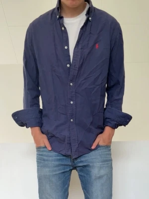 Mörkblå Ralph Lauren skjorta - Mörkblå Ralph Lauren skjorta strl M men sitter som en S. Bra skick utan nåra defekter och hör gärna av er vid frågor elr funderingar!!