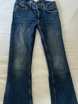 Blå bootcut jeans med slitningar - Storlek 152 alltså barn storlek!Säljer ett par blå lowwaisy bootcut jeans i klassisk denim med lätta slitna detaljer framtill. 