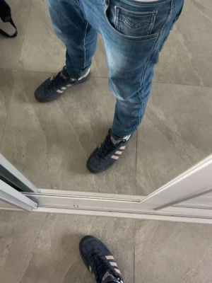 Mörkblå Adidas spezial sneakers med vita ränder - Säljer ett par mörkblå Adidas spezial sneakers med klassiska vita ränder på sidorna. Dessa skor klär till allt och ger dig en fin look. Riktigt snygga och kan va riktigt fräscha nu till sommaren,  lite slitna vid hälen på insidan av skon som ni ser på bilden men annars inga typer av hål eller något, har du några funderingar är det bara att fråga. Priset kan diskuteras! 🫱🏻‍🫲🏼