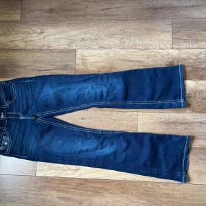 Blå jeans  - Ett par blå jeans med vit söm från Gina Tricot. Har använt men inga skador eller fläckar förutom längst ner som man ser på sista bilden. 