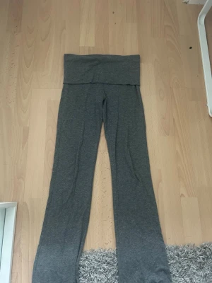 Grå yogabyxor - Mysiga grå leggings med bootcut-ben och bred midjeresår. Perfekta för en avslappnad stil och superbekväma att bära hela dagen. Tillverkade i mjukt stretchigt material som följer kroppen. Dom är i storlek 158/164