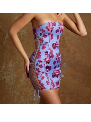 Ljuslila blommig tubklänning med snörning ohpolly - Säljer en kort, figurnära tubklänning i ljuslila med rosa blommönster och snörning längs sidorna🌸 ny med lapp aldrig använd från oh polly