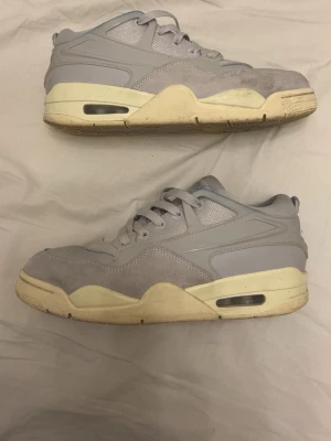 Gråa sneakers med mesh och mocka - Snygga sneakers i ljusgrått med ovandel i mesh och mocka samt detaljer i slät syntet. Sulan är vit med inslag av beige och har synlig luftbubbla på sidan. Klassisk låg modell med snörning och sportig vibe.