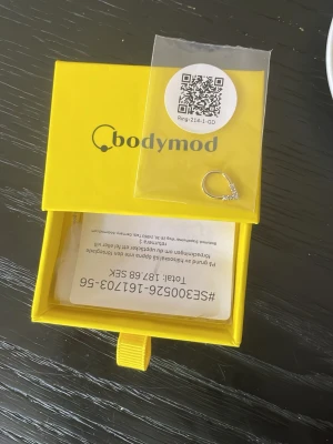 Guldfärgad septumring med stenar - Snygg guldfärgad septumring från Bodymod med fem gnistrande klara stenar i en V-formad design. Perfekt för dig som vill ha en unik och trendig detalj till din piercing. Kommer i originalförpackning. 7mm x 1mm helt oanvänd. Annonsen finns på Vinted också :)