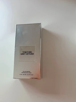 Tom Ford Grey Vetiver Eau de Parfum 50ml - Elegant. Fräsch. Karismatisk. Med ett elegant och sofistikerat hjärta av vetiver i en perfekt kombination av frisk citrus, varma kryddor och utsökta tränoter utgör Tom Ford Grey Vetiver essensen av stilren, karismatisk och provocerande maskulinitet. För män. Doftnoter: Apelsinblomma, grapefrukt, muskotnöt, pimento, vetiver, slånlav